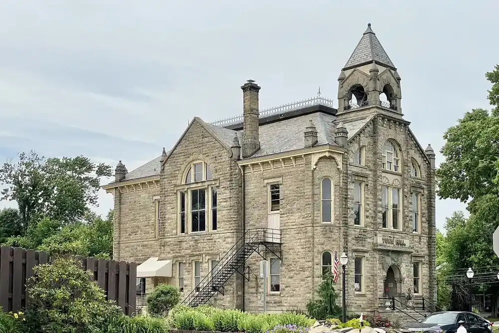 The sandstone Amherst City Hall with its tower and garden in Amherst, Ohio