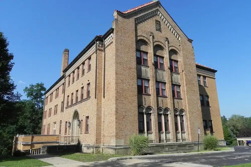 The tall yellow-brick Villa San Bernardo building beside a lawn in Bedford, Ohio