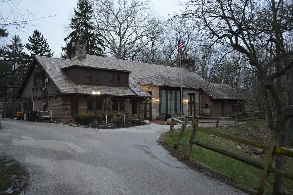 The stone and timber Bain Cabin among bare trees in a Fairview Park, Ohio park