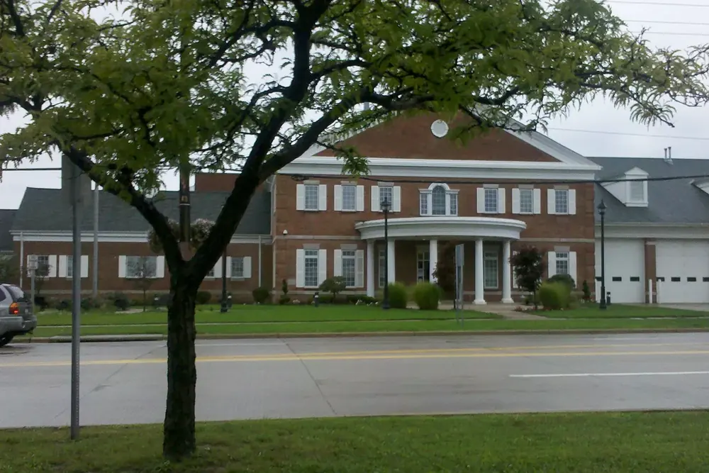 The brick Mayfield Heights city hall with white columns along a tree-lined street in Ohio