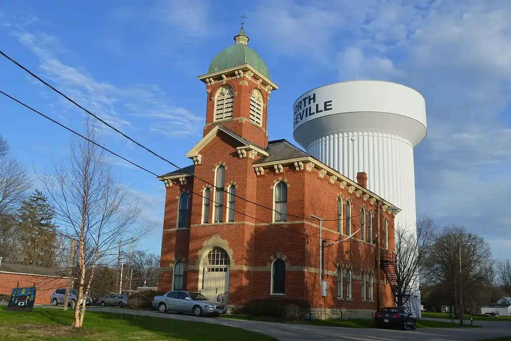 The historic brick North Ridgeville City Hall in front of the city water tower in Ohio